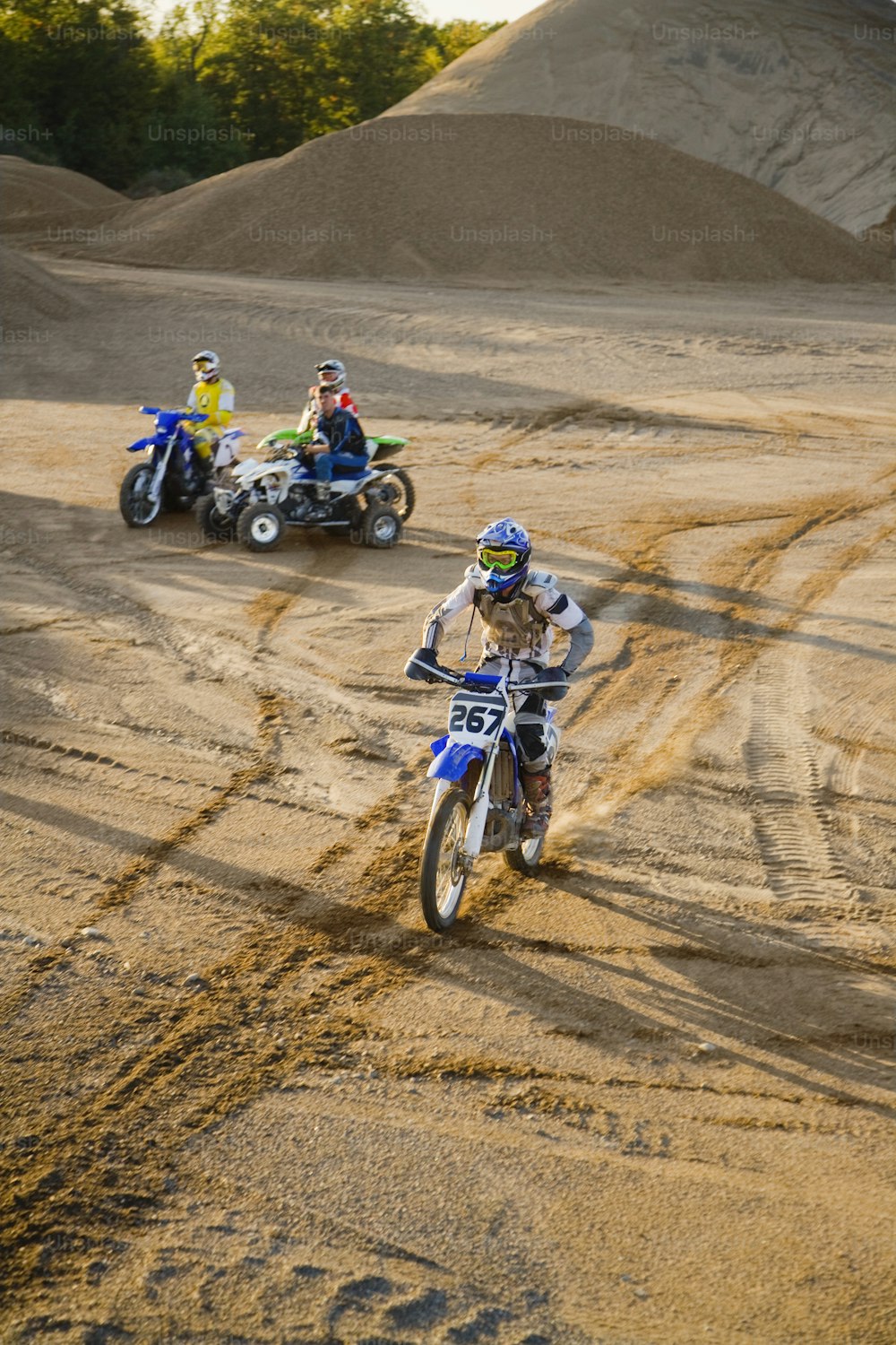 a group of people riding dirt bikes on a dirt road