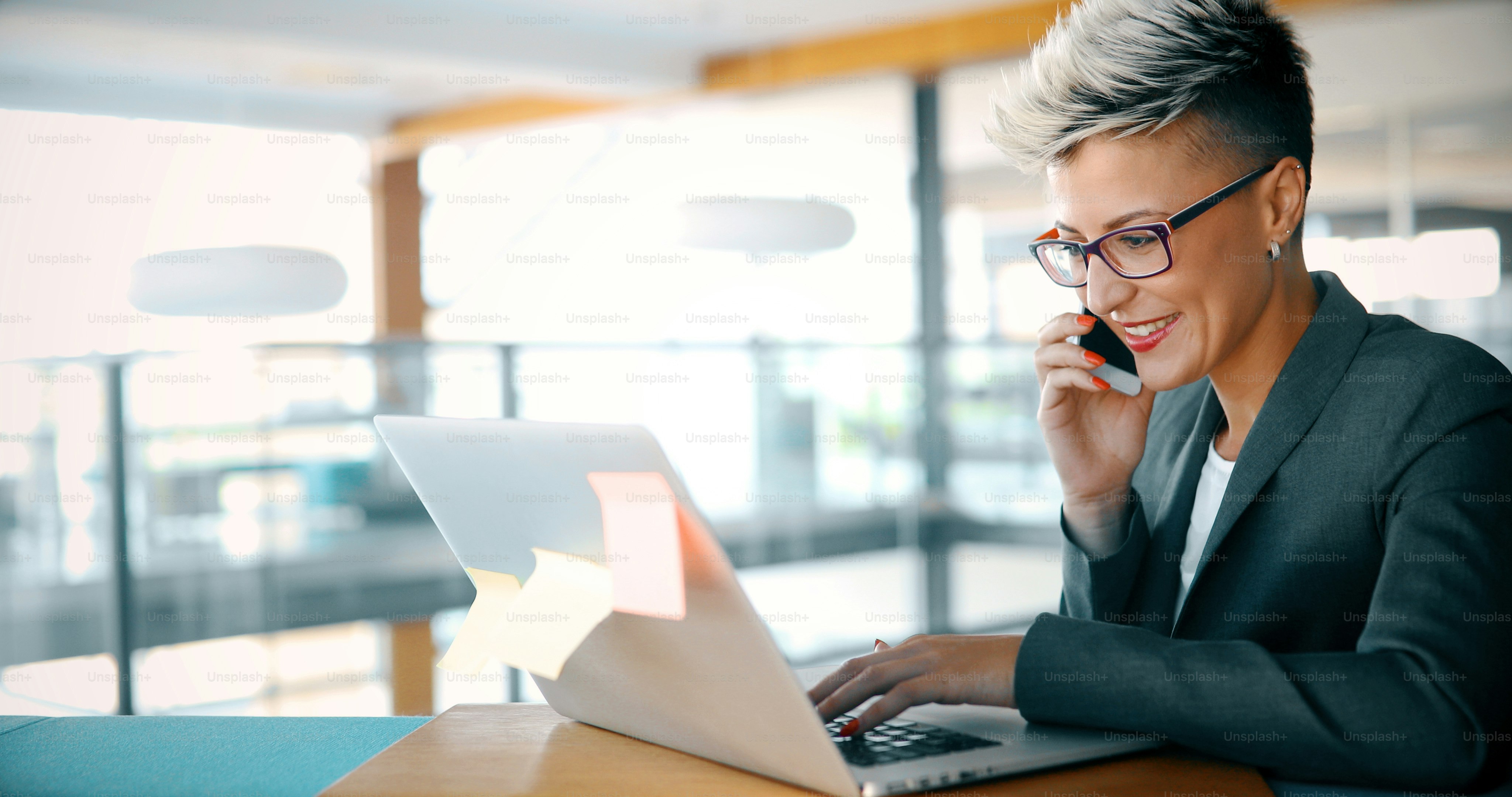 Attractive young female architect working on laptop in office