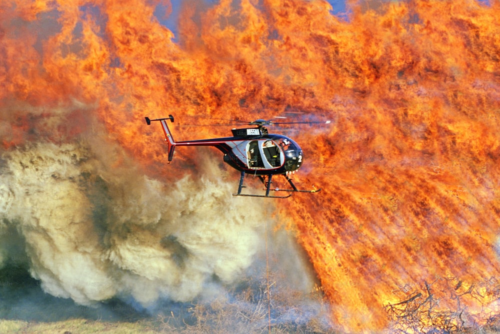 헬리콥터가 큰 불 위로 날고 있습니다