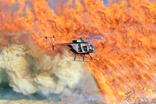 a helicopter is flying over a large fire