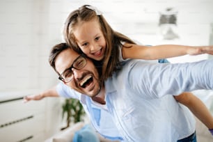 Portrait of father and daughter playing at home together