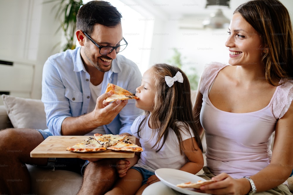 Happy smiling family sharing pizza together at home