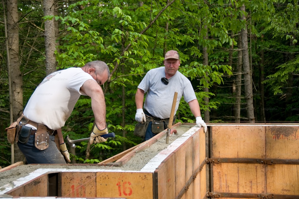 Due uomini che lavorano a un progetto di costruzione nel bosco