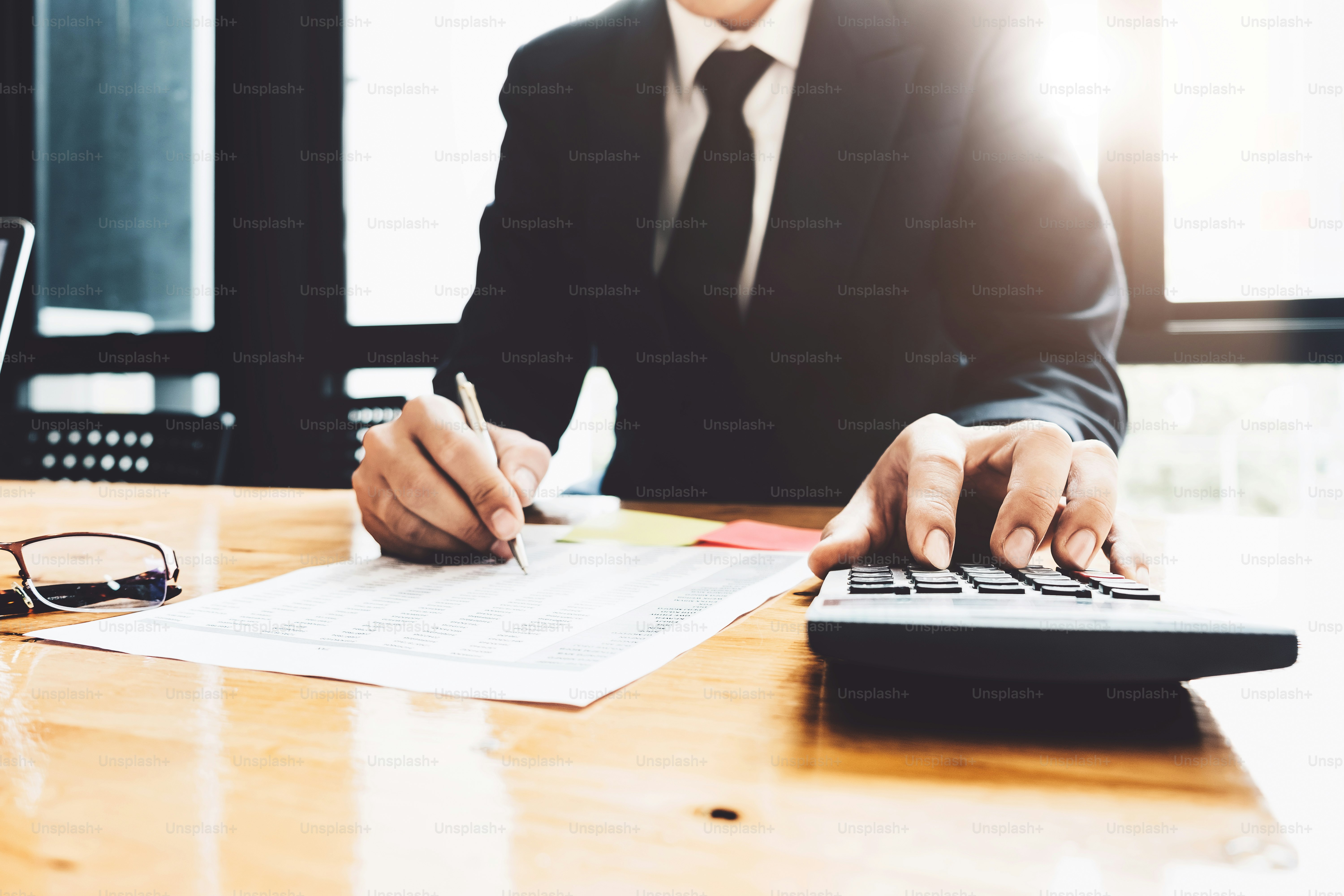 Close up of businessman or accountant hand holding pen working on ...
