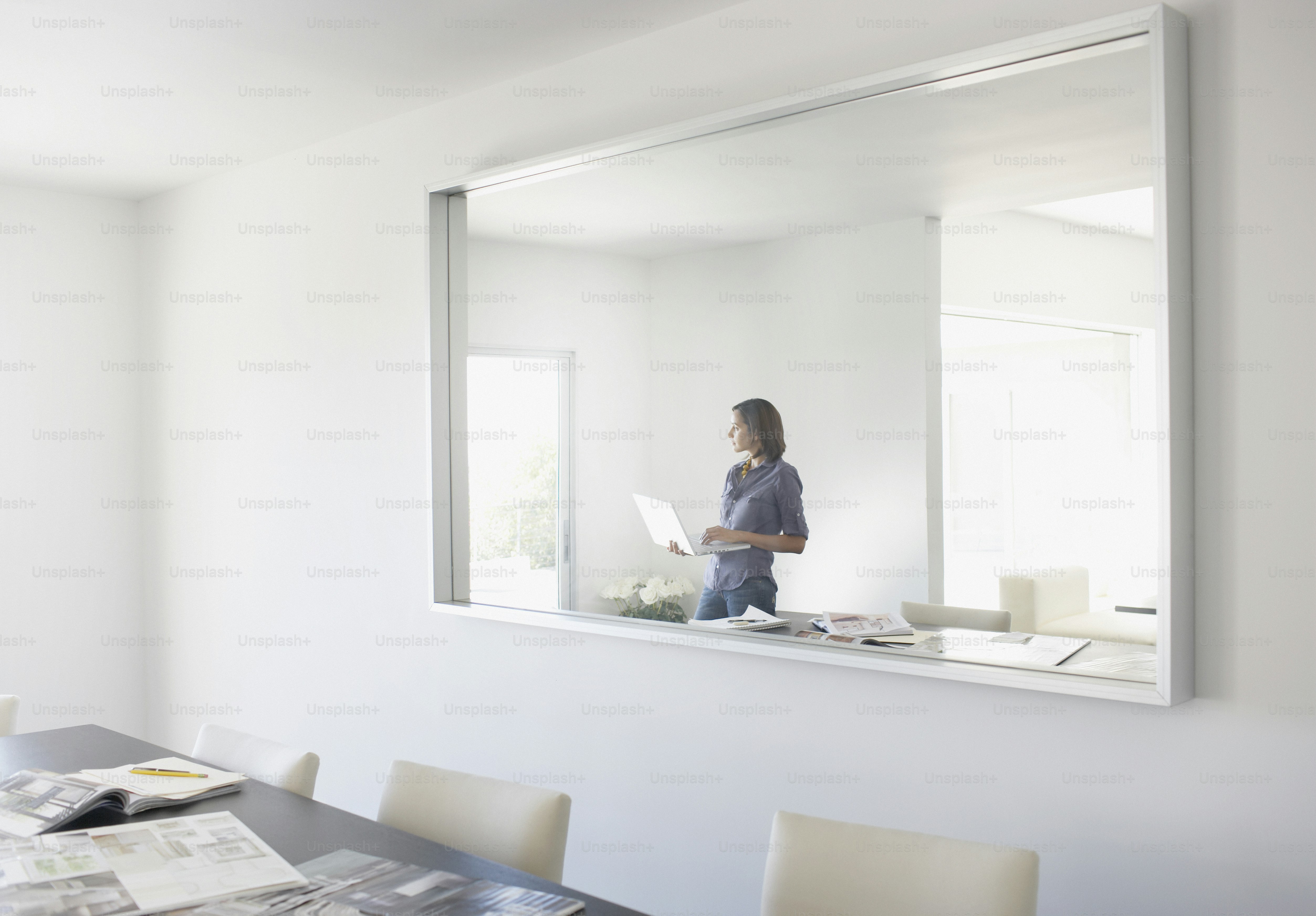 a woman standing in front of a mirror on a wall