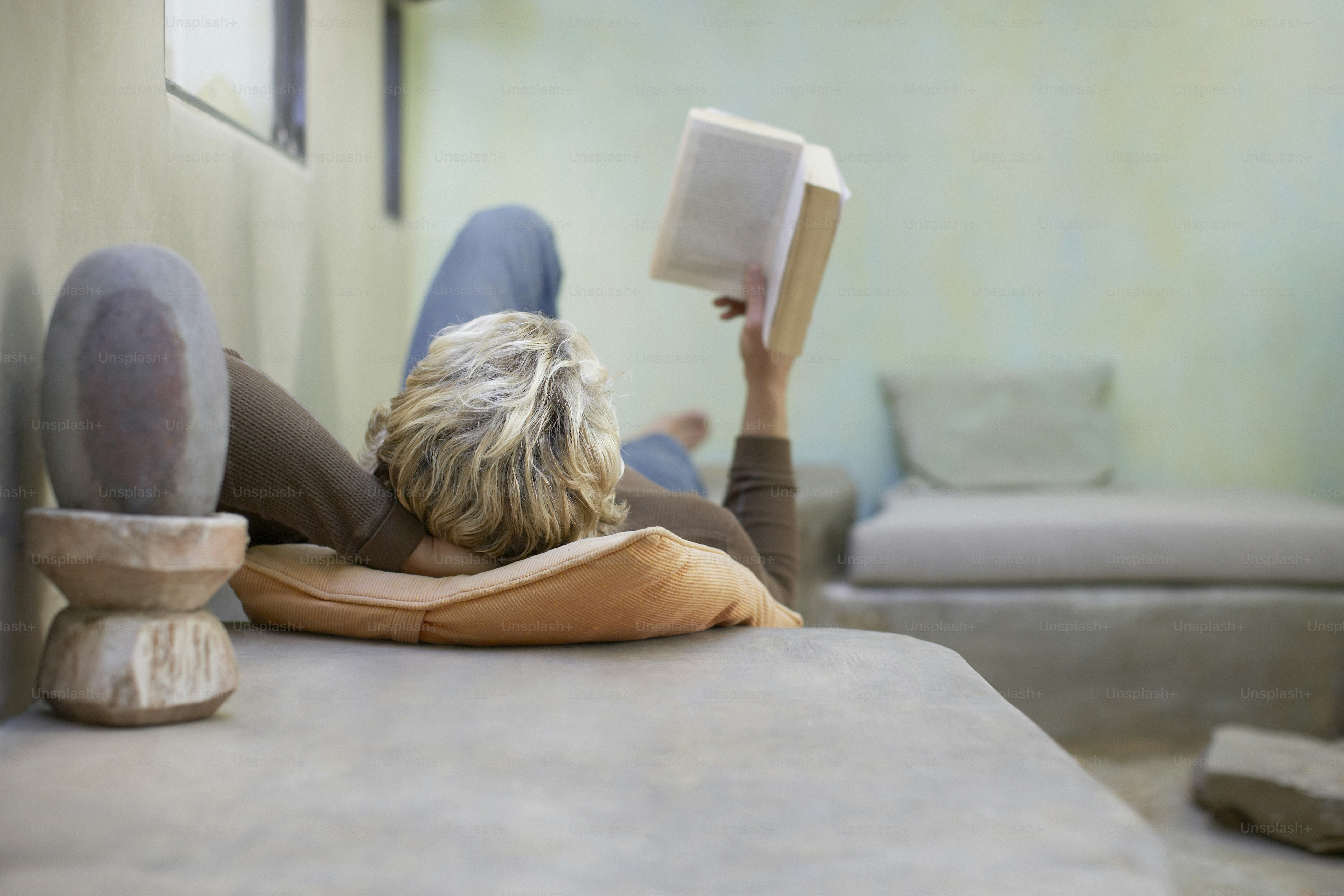 a woman laying on the floor reading a book