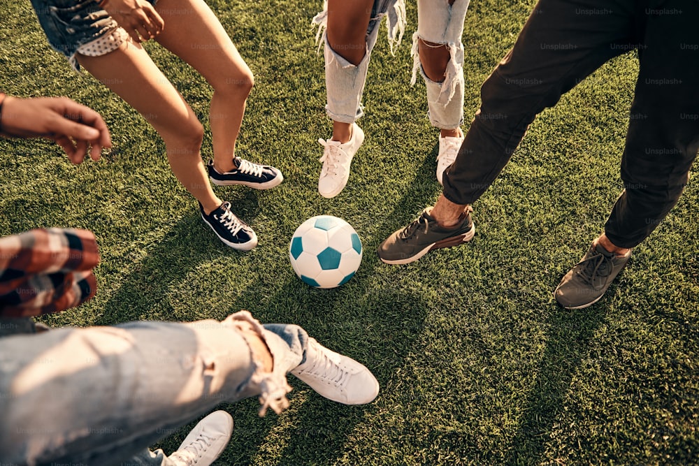 Nahaufnahme von Jugendlichen in Freizeitkleidung, die Fußball spielen, während sie Zeit im Freien verbringen