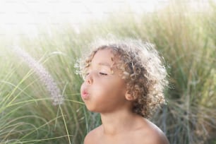 a young boy with curly hair blowing in the wind
