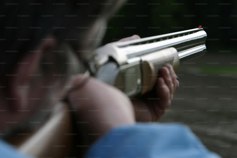 a man holding a gun in his right hand