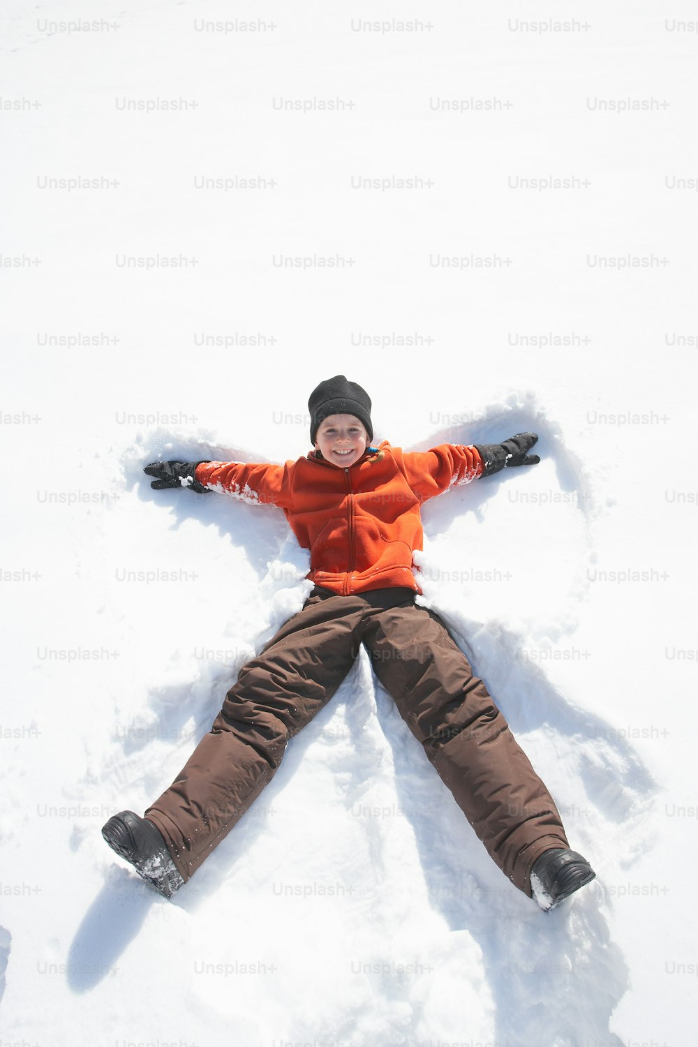 a person laying in the snow on their back