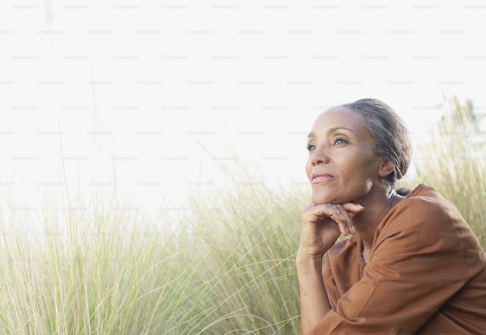 a woman sitting in a field of tall grass