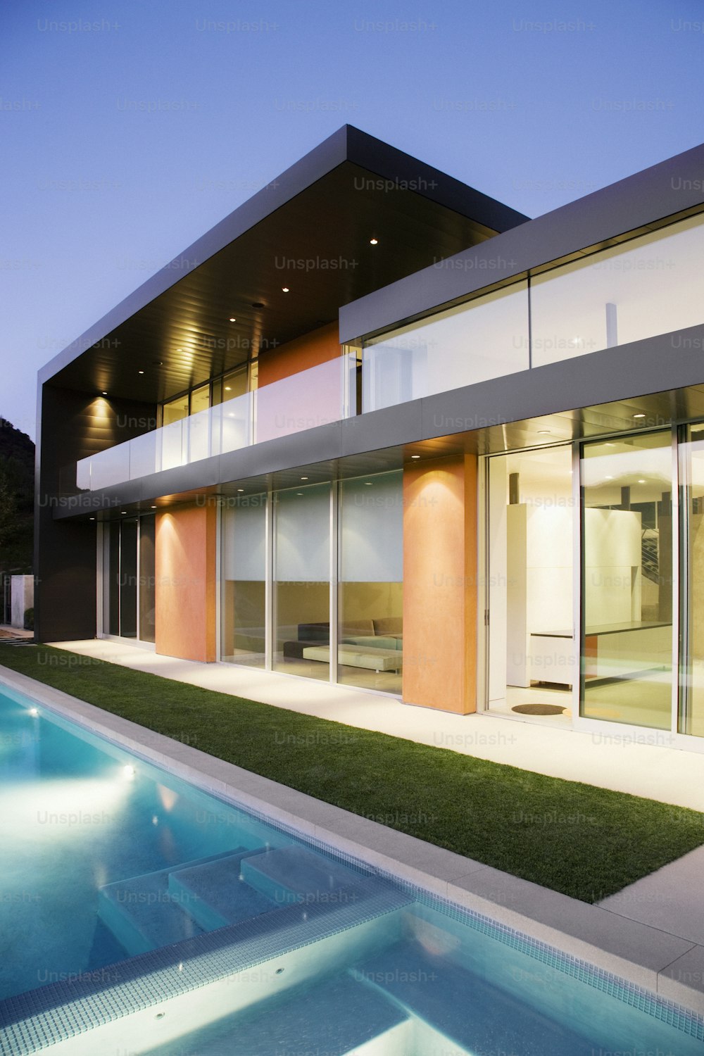 a modern house with a swimming pool in front of it