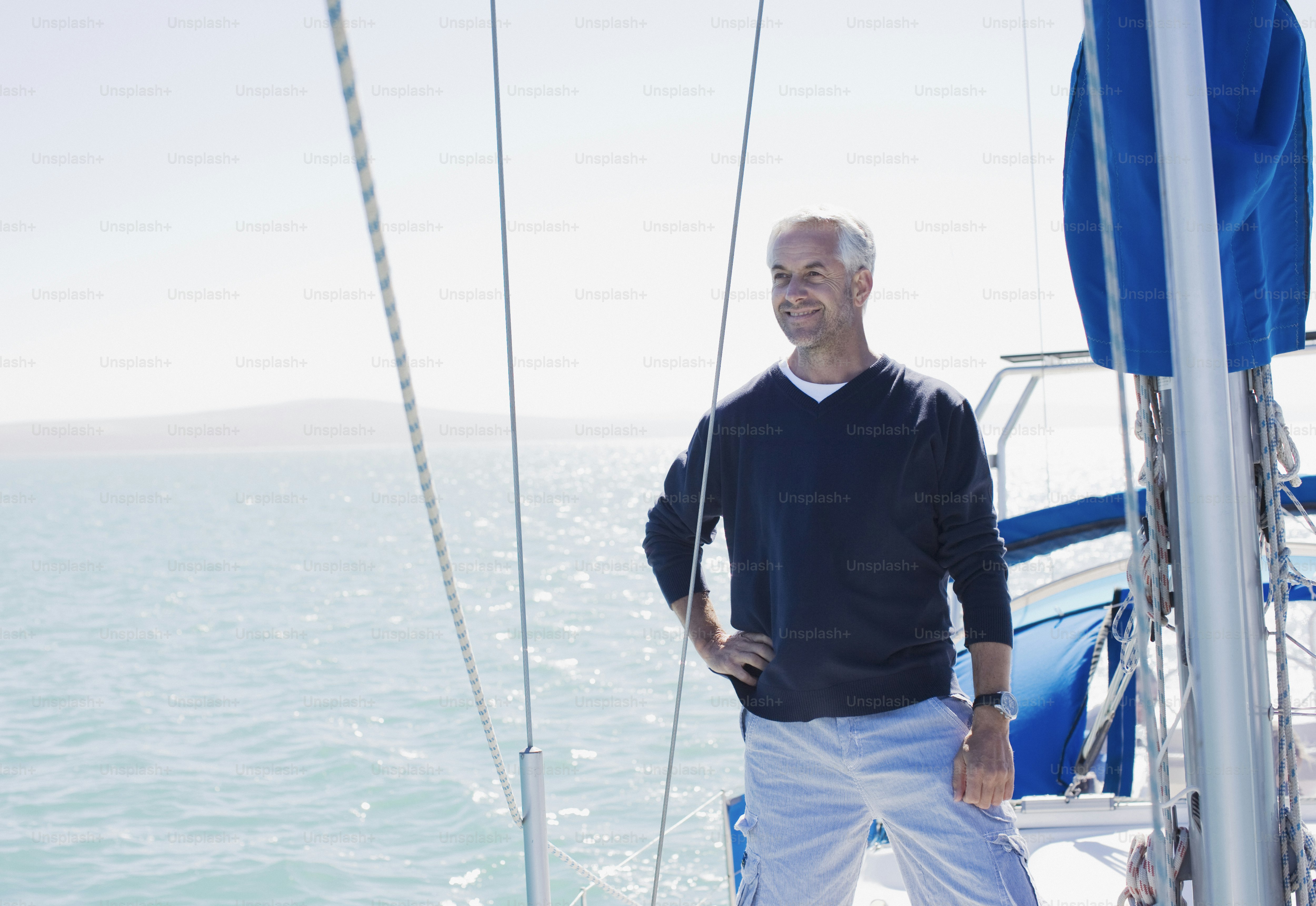 a man standing on the deck of a sailboat
