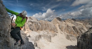 alpinista masculino em uma íngreme e exposta Via Ferrata com uma vista fantástica no sul do Tirol, nas Dolomitas italianas