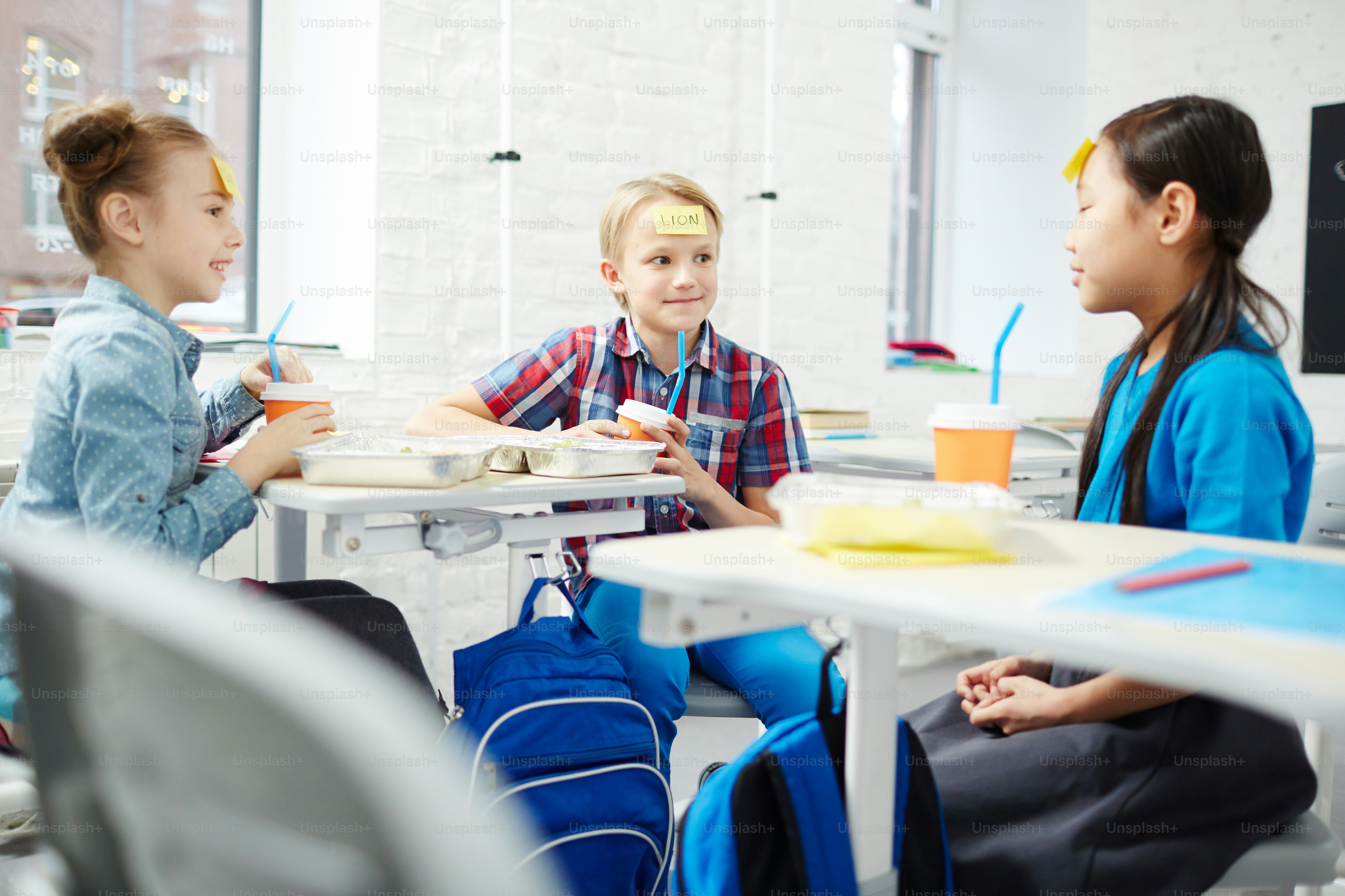 Adorable schoolkids playing name game at lunch break between classes ...