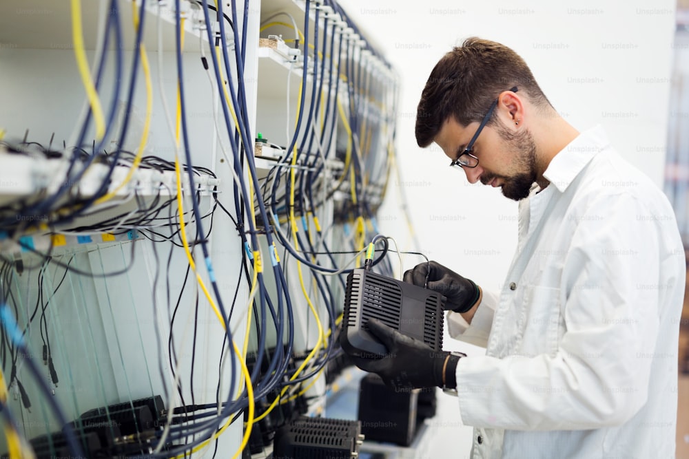 Immagine dell'ingegnere tecnico di rete che testa i modem in fabbrica