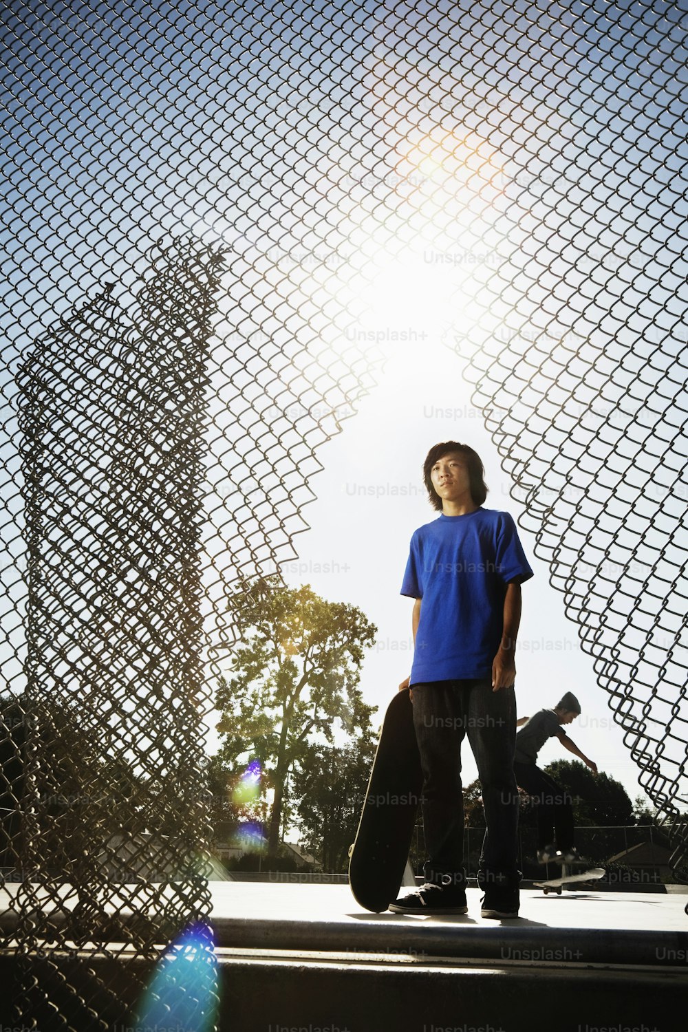 a young man standing next to a skateboard