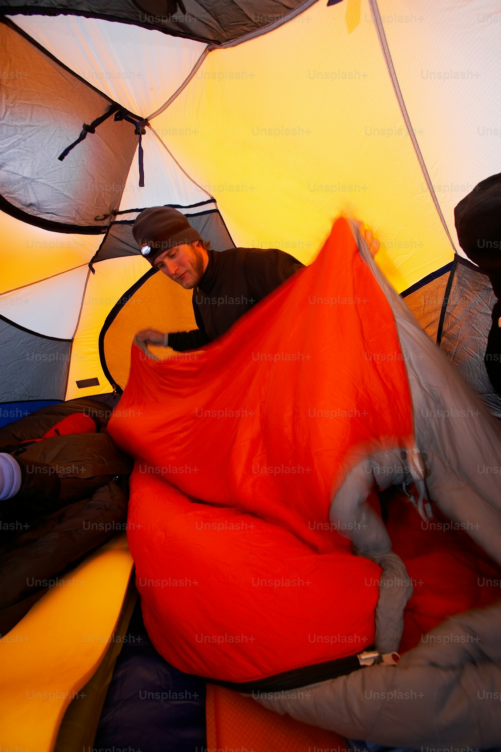 テントの中のベッドに横たわる男
