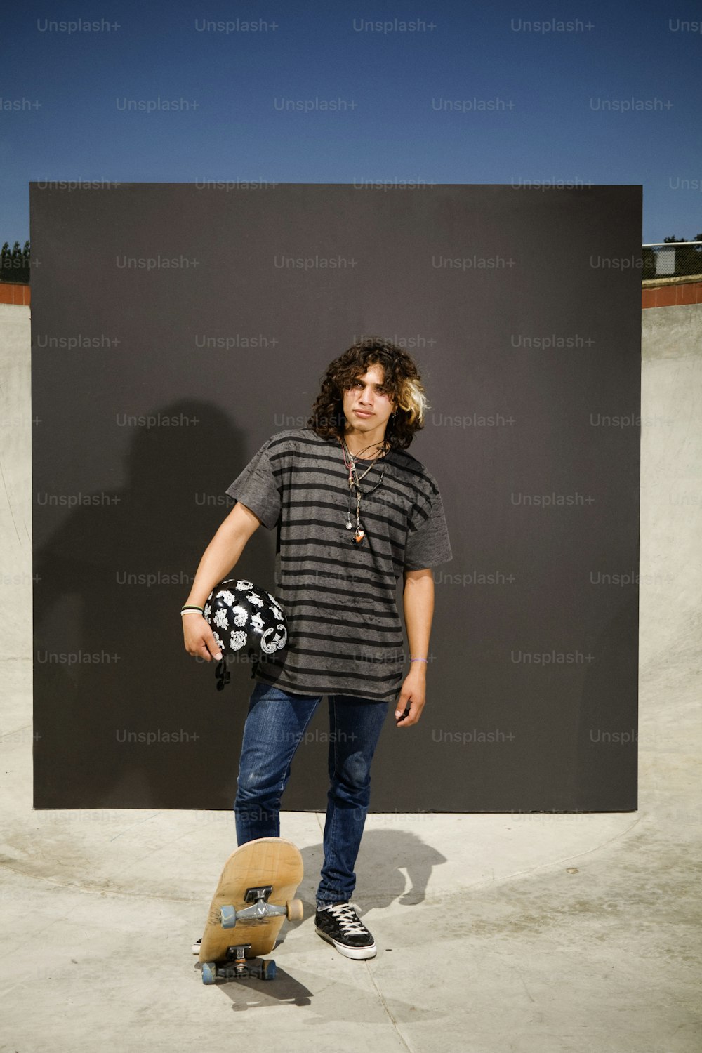 a man standing next to a skateboard in a skate park