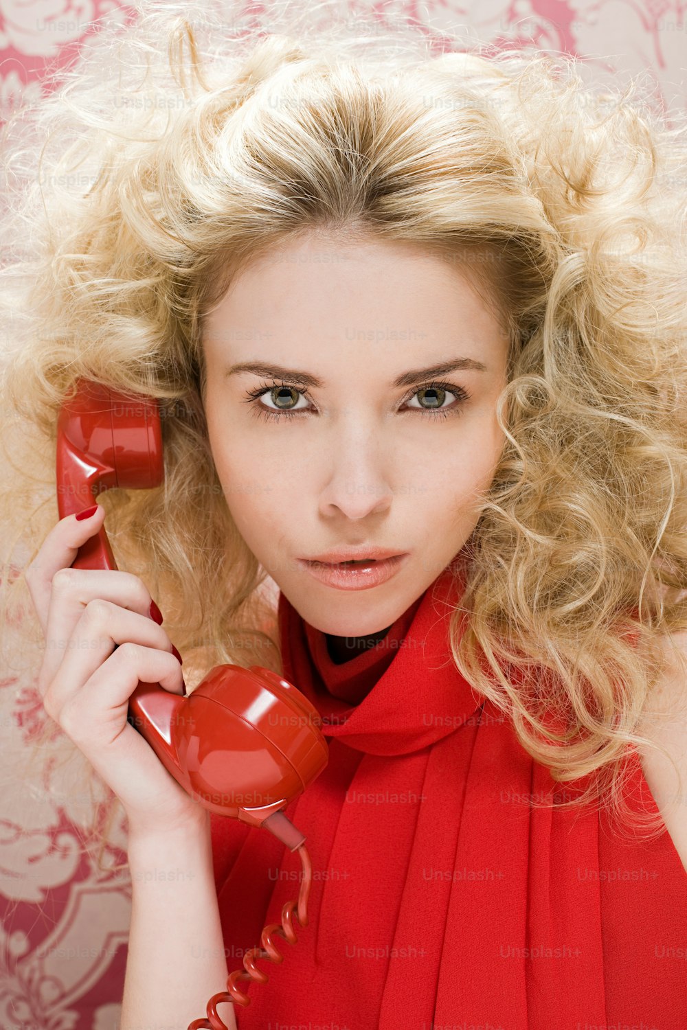 a woman in a red dress talking on a red phone