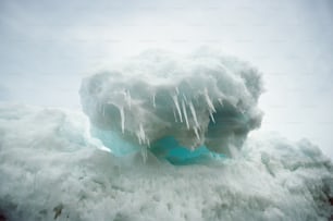 um grande iceberg com pedras penduradas nas laterais