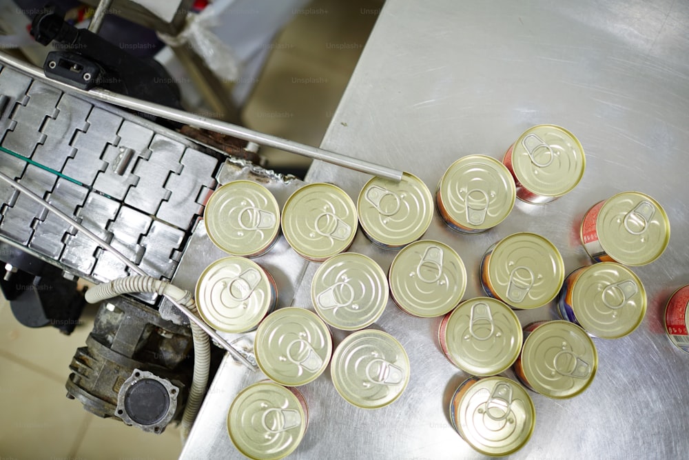 Latas embaladas com peixe ou frutos do mar sendo colocados na linha de processamento na fábrica