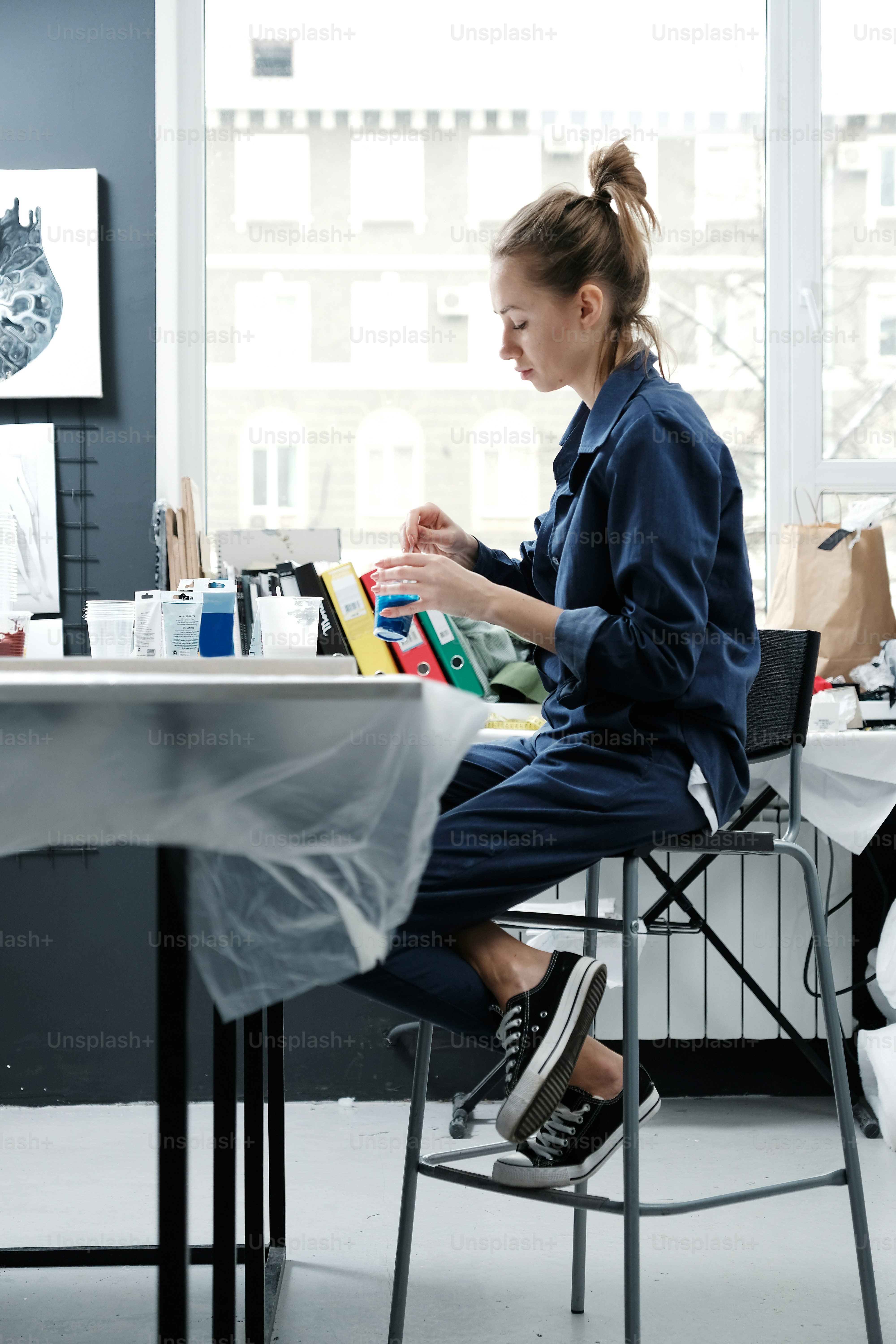 Young girl artist in the Studio is provisioned, mix acrylic paint, prepares the way for drawing. A woman painter. Accessories for drawing. A new technique of painting. Canvas, frame. Art workshop. Creative ideas. Abstraction