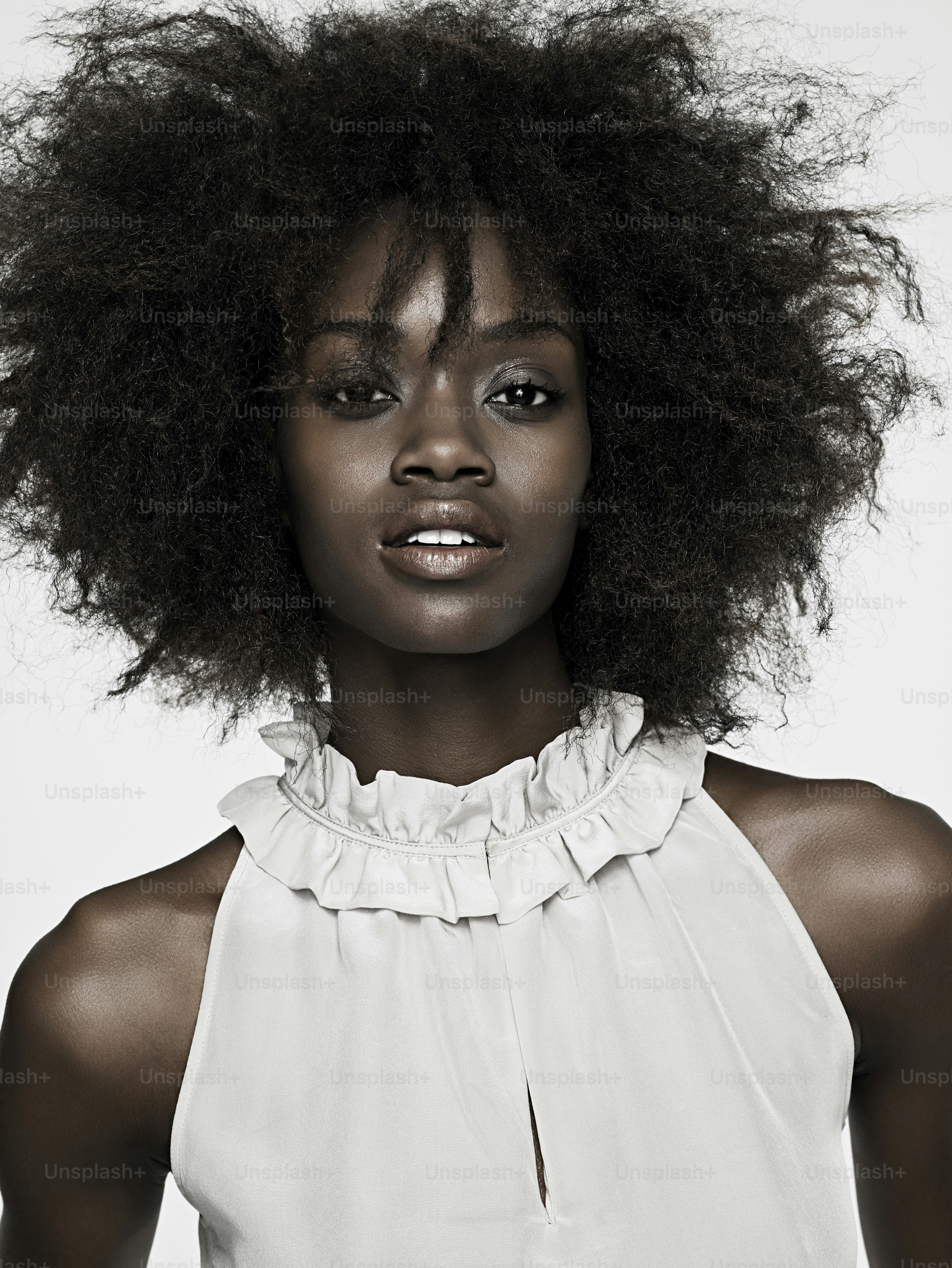 a woman with an afro is posing for a picture