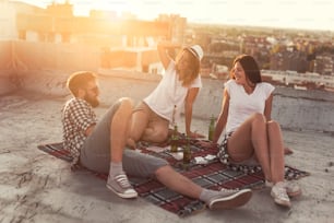 Giovani che si rilassano e fanno festa sul tetto di un edificio. Concentrati sulla ragazza nel mezzo