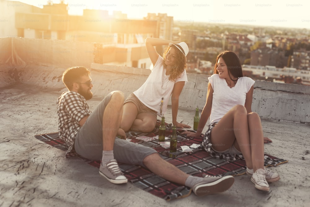 Young people chilling out and partying on a building rooftop. Focus on the girl in the middle