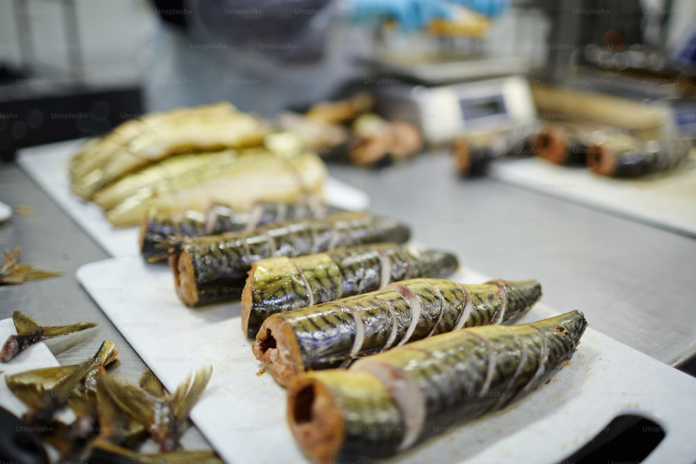Row of appetizing smoked sliced herrings ready to be canned for sale