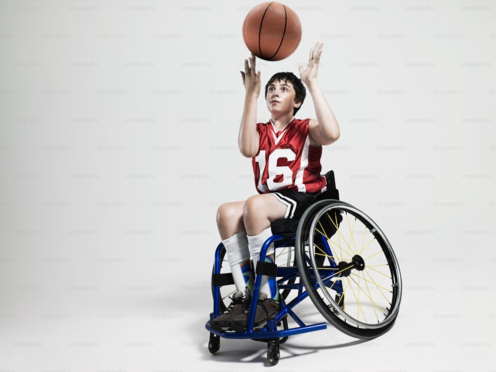a man in a wheel chair holding a basketball