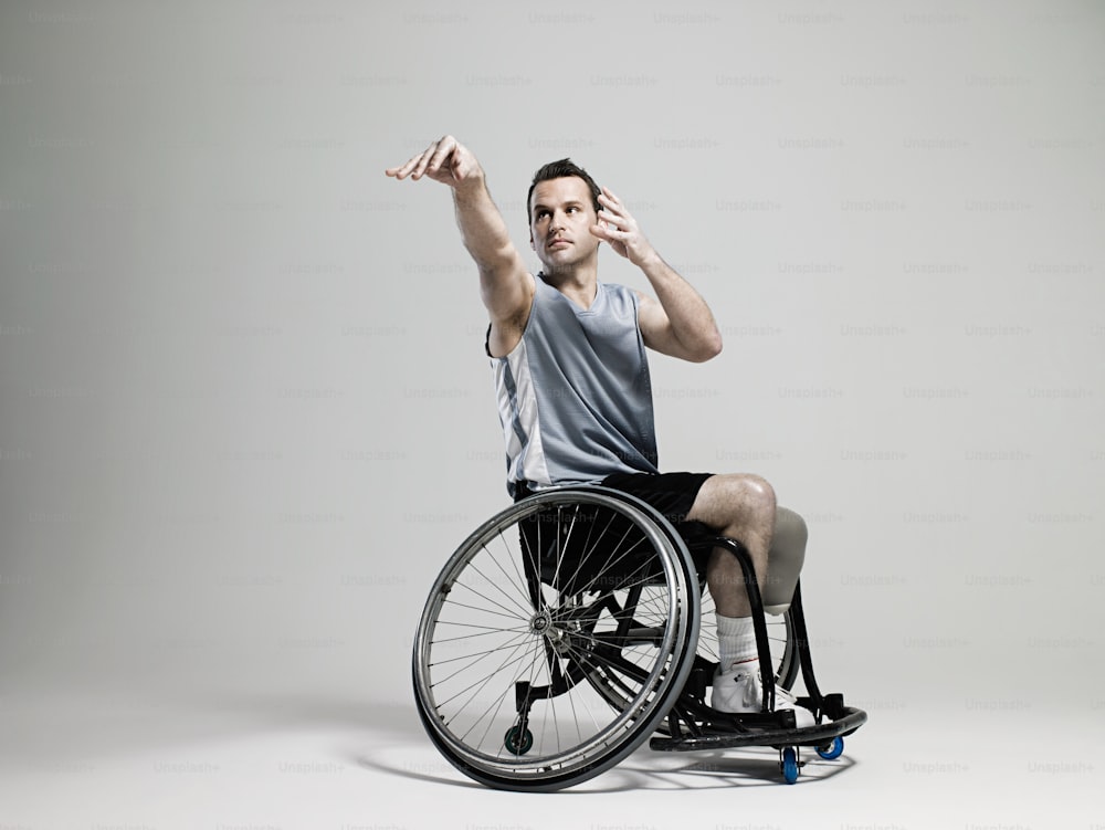 um homem em uma cadeira de rodas segurando a mão para cima