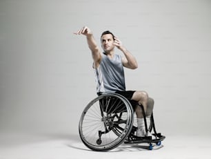 Un homme en fauteuil roulant levant la main