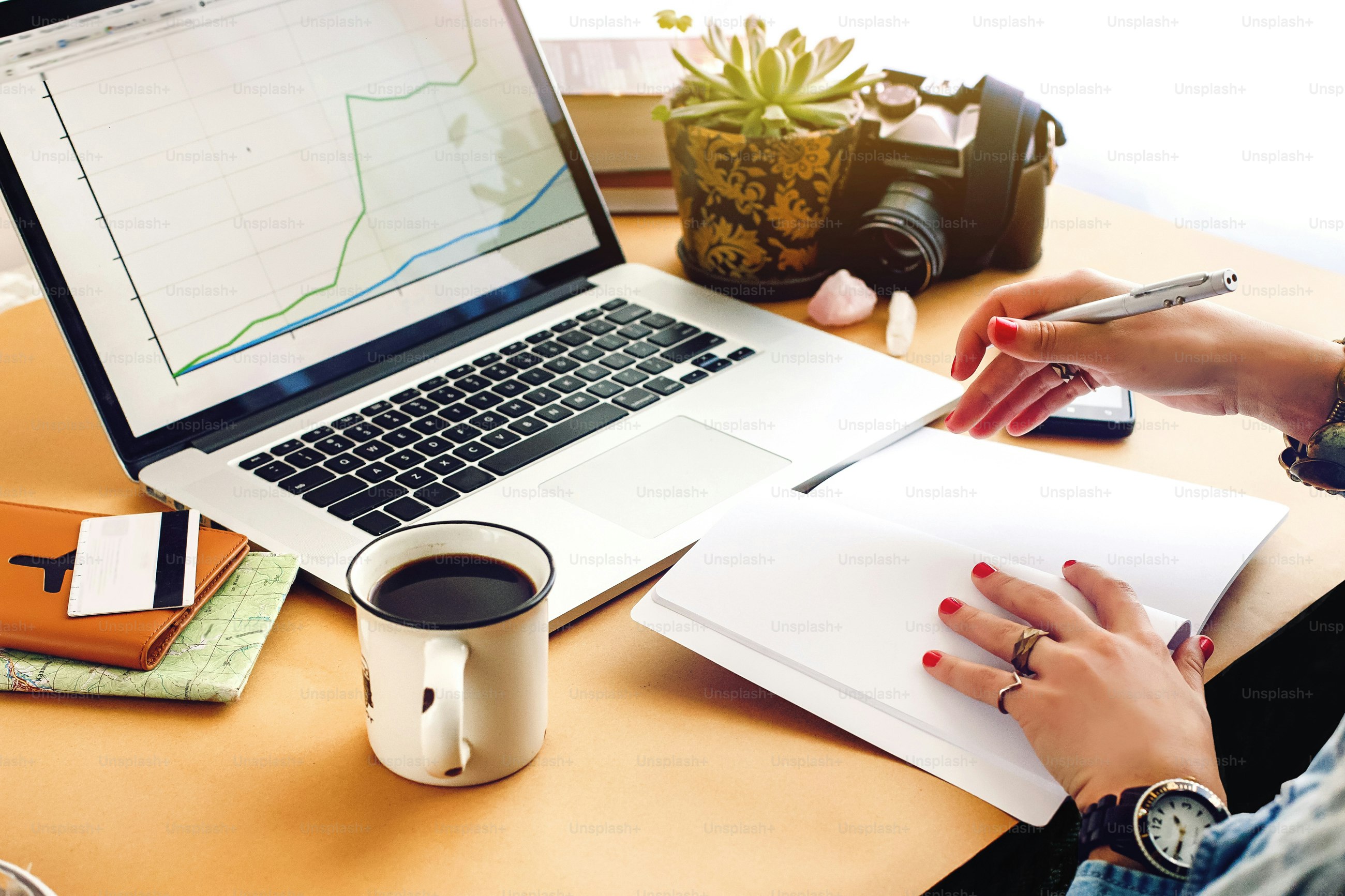 stylish young hipster girl working economist financial analytics holding pen on craft background with laptop and papers