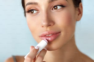 Lips Protection. Beautiful Woman With Beauty Face, Full Lips Applying Lip Balm, Lipcare Stick On. Portrait Of Female Model With Natural Makeup. Lips Skin Care Cosmetics Concept. High Resolution