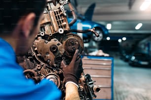 Professional Mechanic Repairing Car Engine in Garage.
