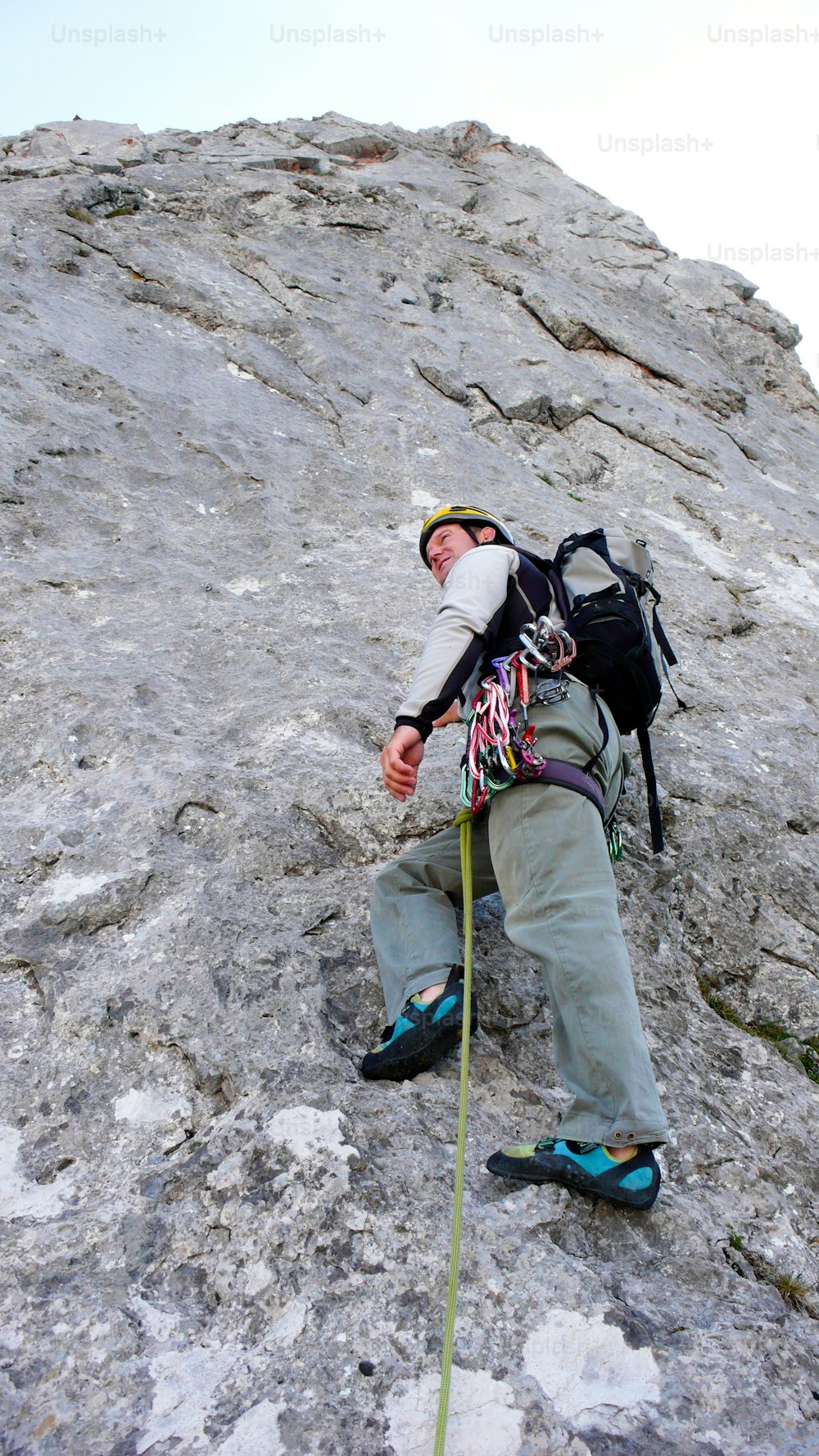 A mountain guide at the start of a steep climbing route in the Swiss Alps