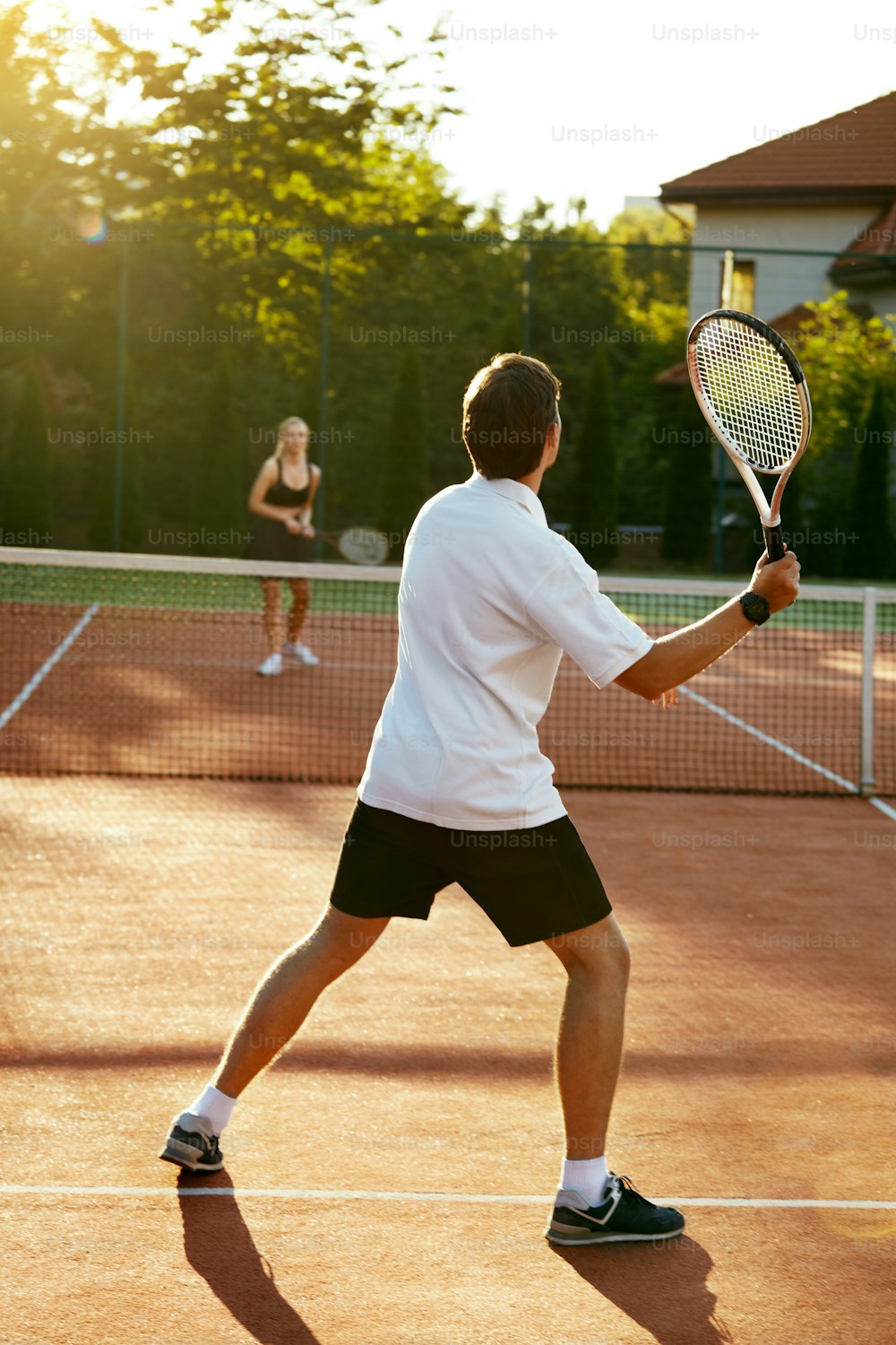 Young People Playing Tennis Outdoors. Healthy Active Man And Woman Holding Rackets In Hands Playing Tennis Match On Open Court On Sunny Summer Day. Sports And Lifestyle. High Resolution.