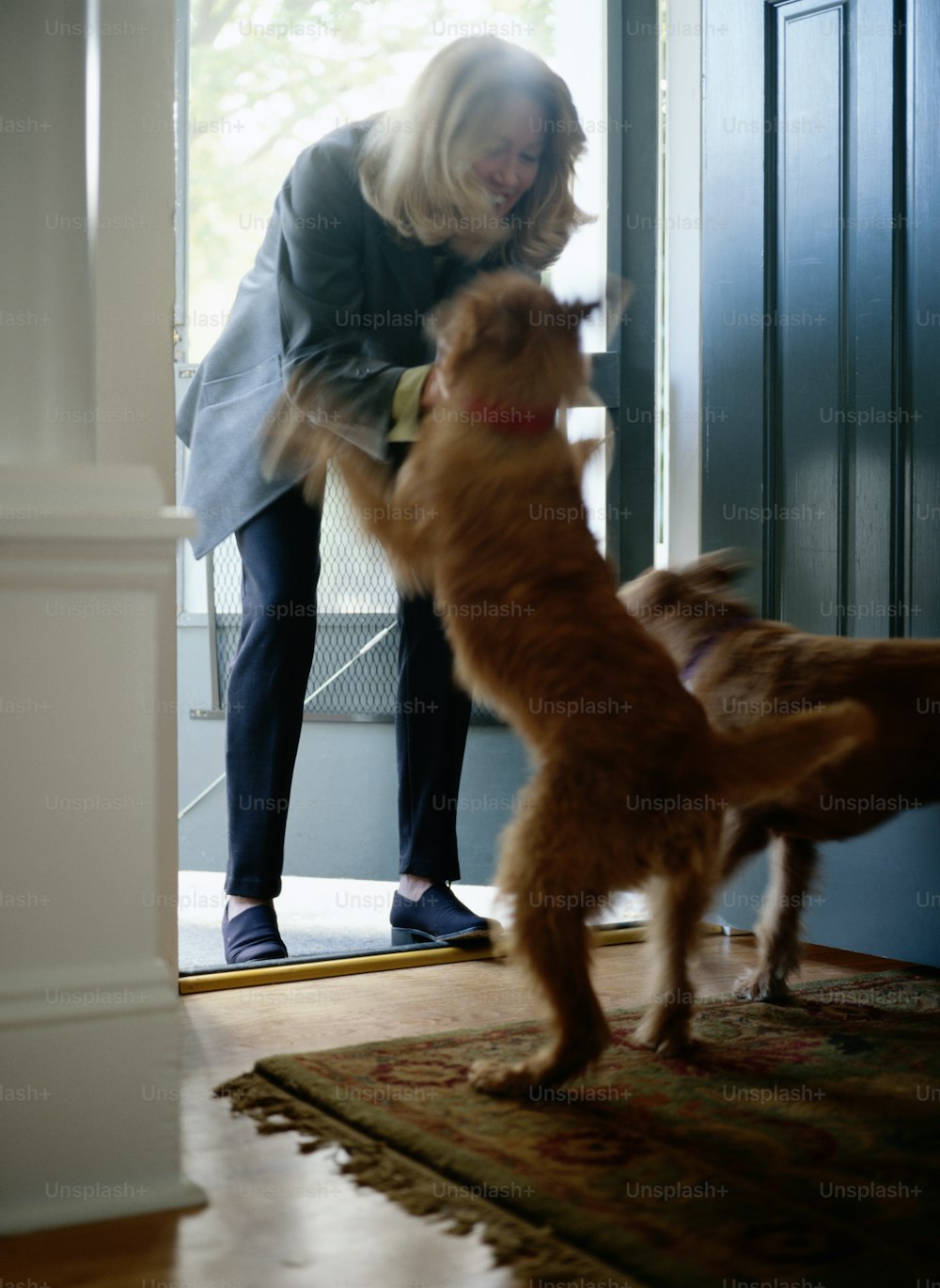 a woman standing next to a dog on top of a rug