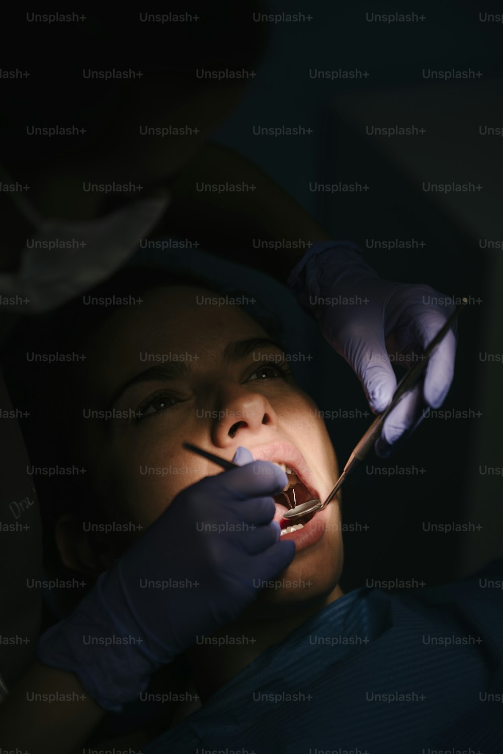 Zahnärzte mit einem Patienten während eines zahnärztlichen Eingriffs. Zahnarztkonzept