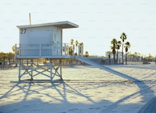 a lifeguard tower on a beach with palm trees