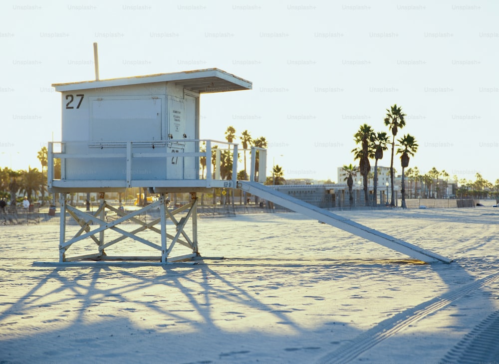 una torre di salvataggio su una spiaggia con palme