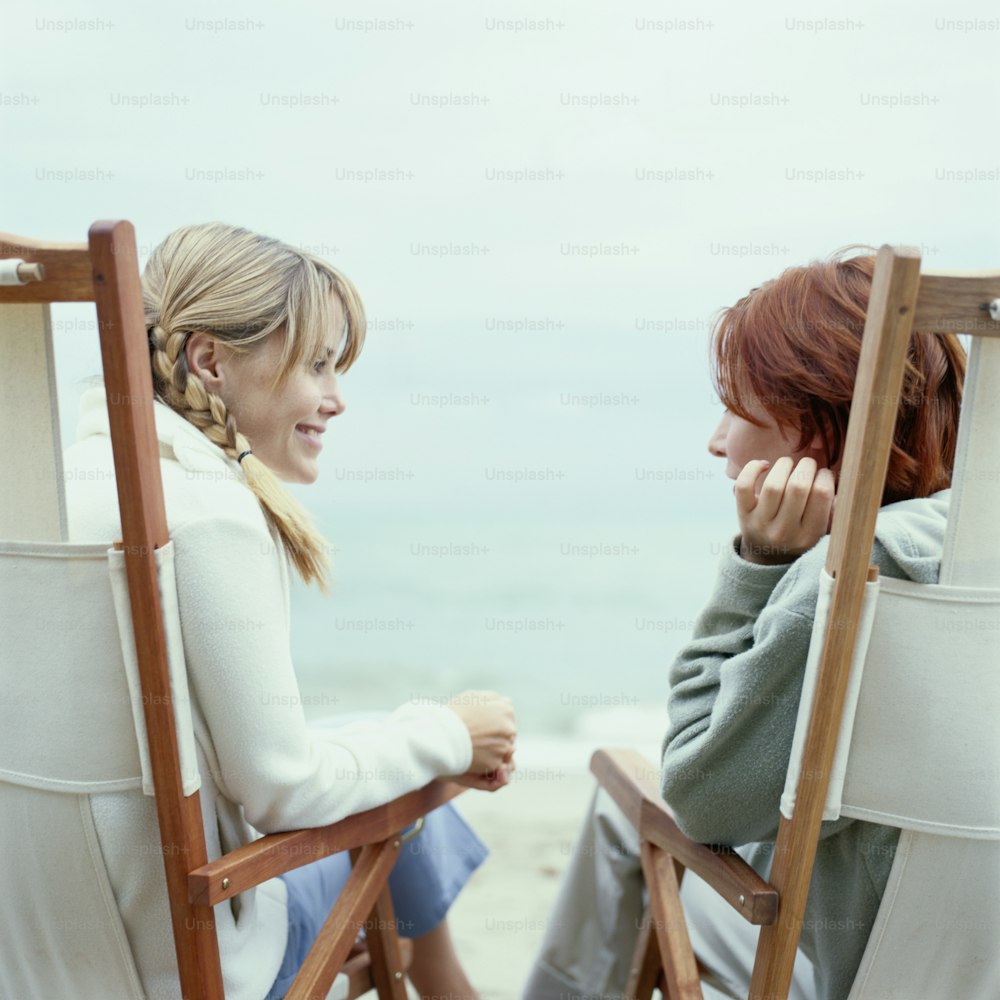 two women sitting in lawn chairs facing each other