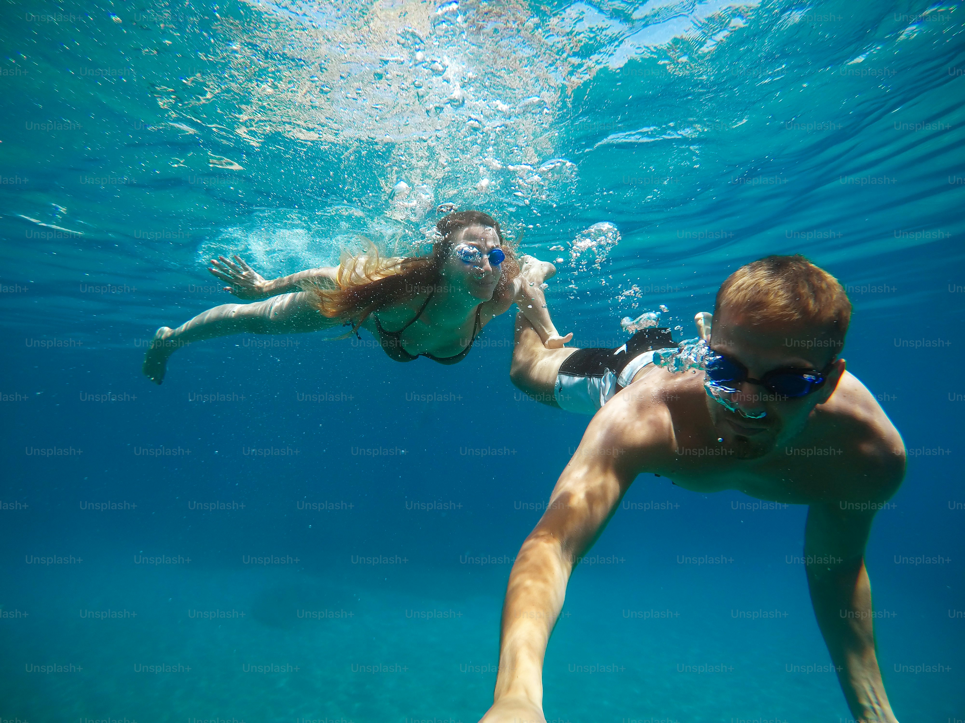 Cheerful couple having fun underwater and making selfie.