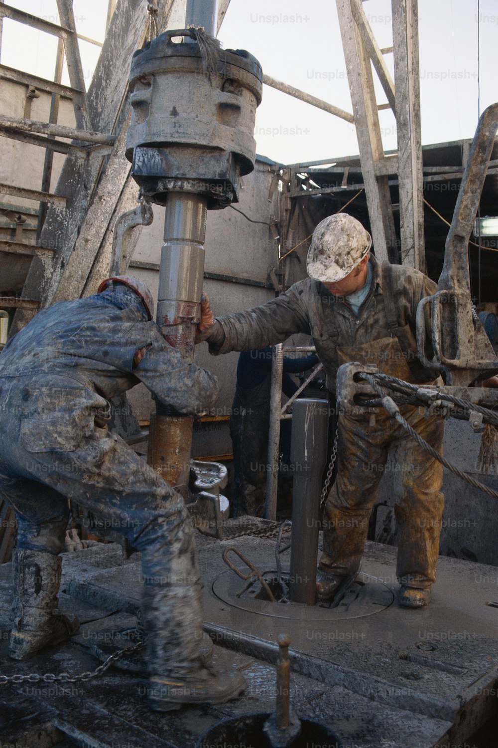 two men working on a machine in a factory