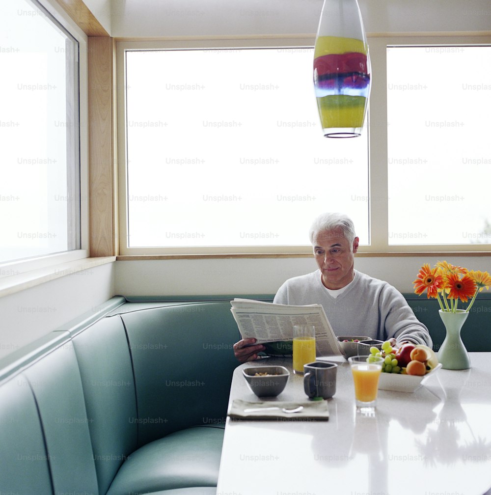 a man sitting at a table reading a newspaper