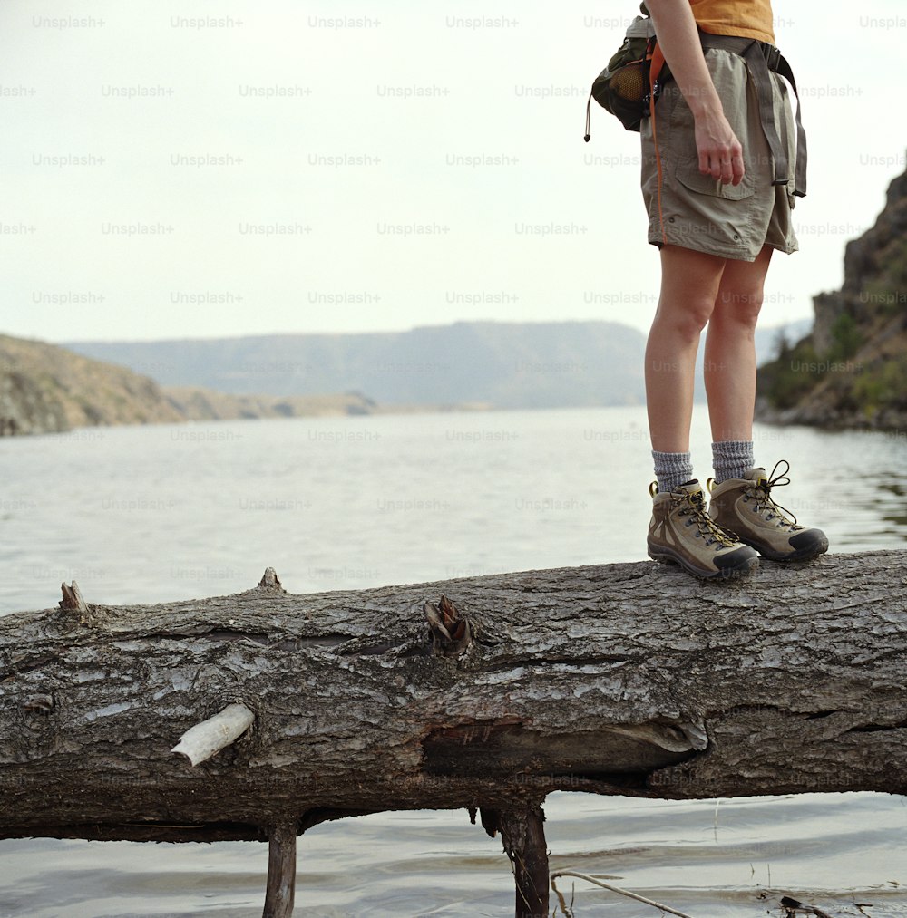 a person standing on a log over a body of water