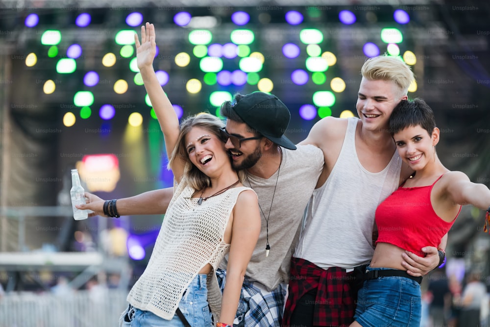Glückliche junge Freunde haben Spaß auf Musikfestival