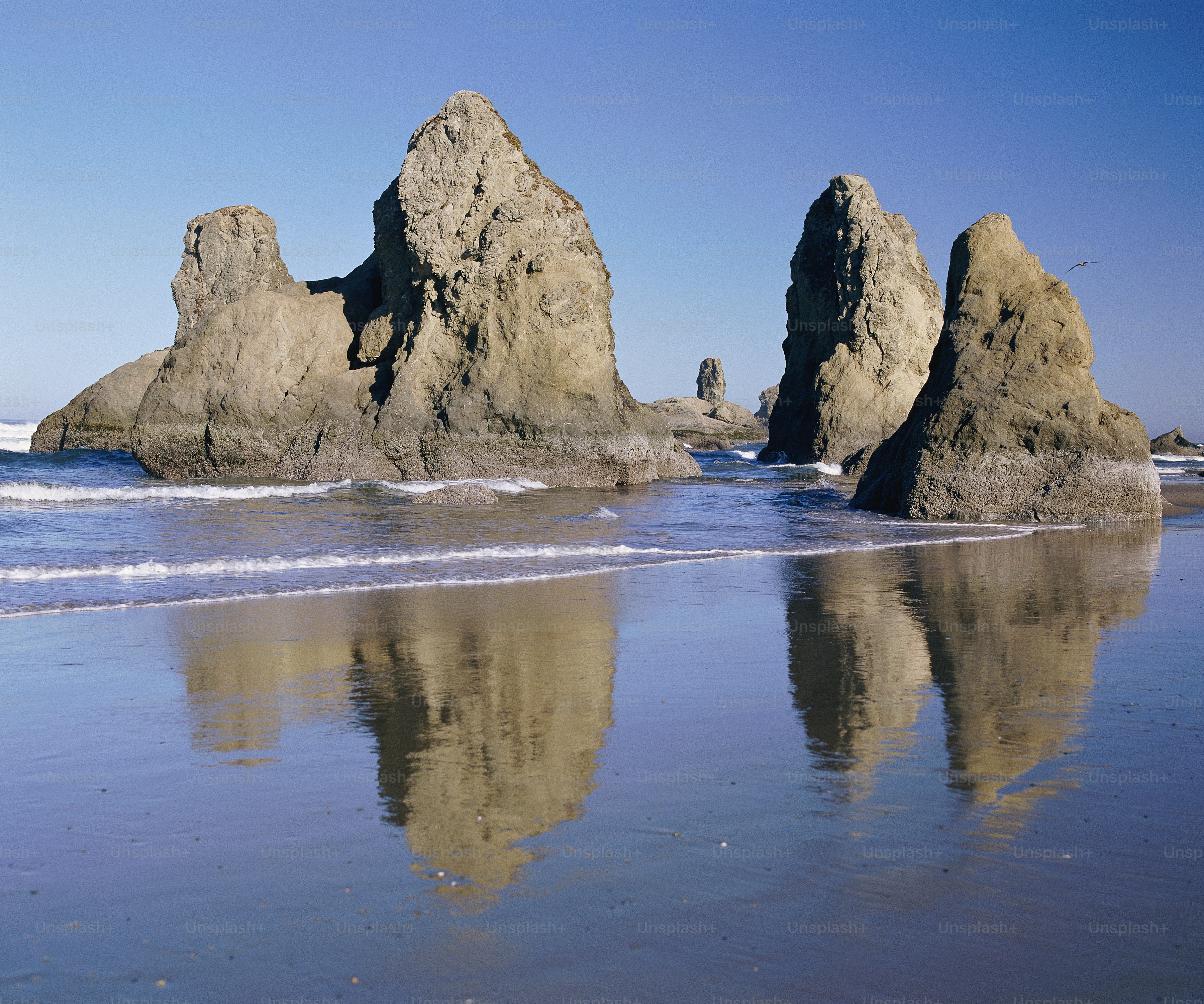 a beach with some rocks in the water